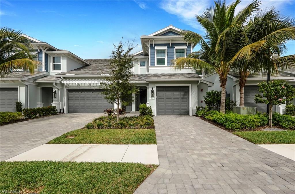 View of front of property featuring driveway, an attached garage, and stucco siding