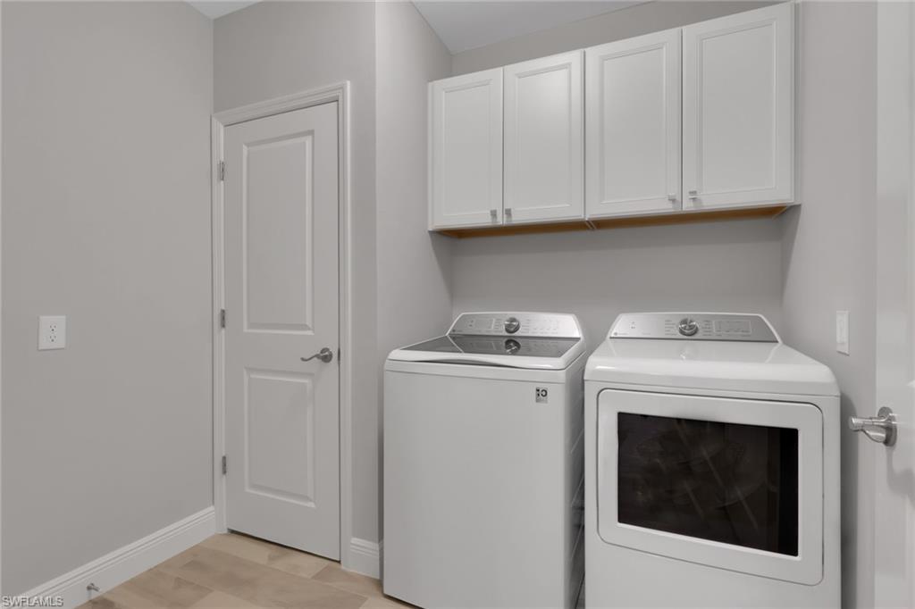 2647 Seychelles Circle, Unit 2202 Naples, FL 34112 - Photo 19 of 37 Laundry area featuring washing machine and dryer and cabinet space