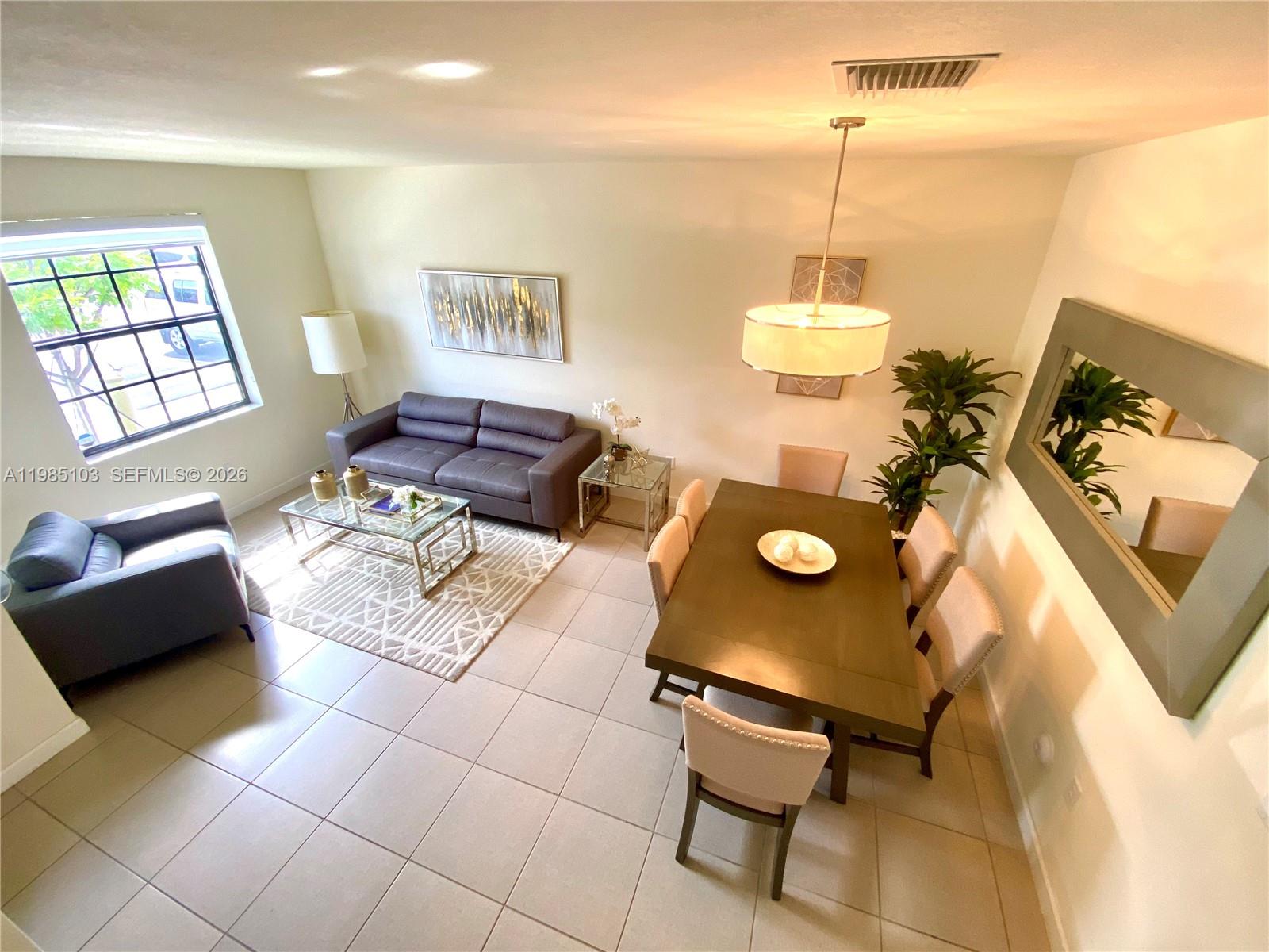 11489 Southwest 250th Street, Unit 11489 Homestead, FL 33032 - Photo 11 of 24 a living room with furniture and a window