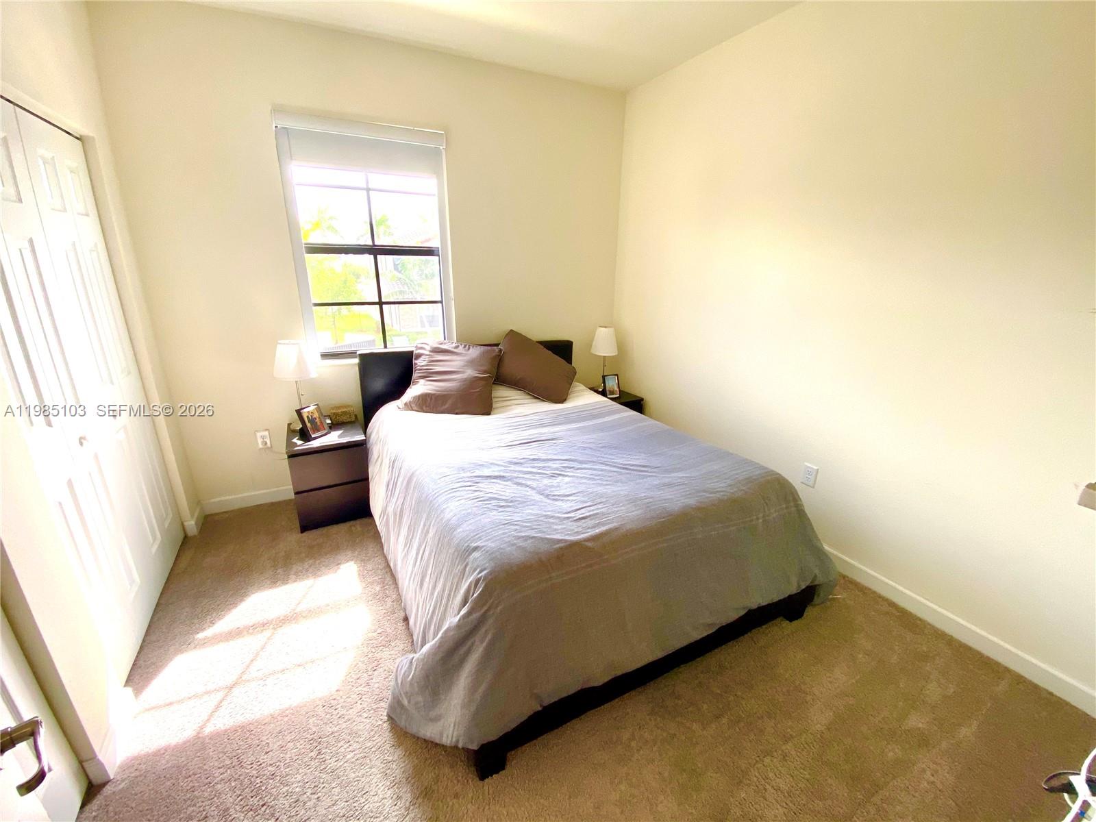 11489 Southwest 250th Street, Unit 11489 Homestead, FL 33032 - Photo 14 of 24 a bedroom with a bed and a window