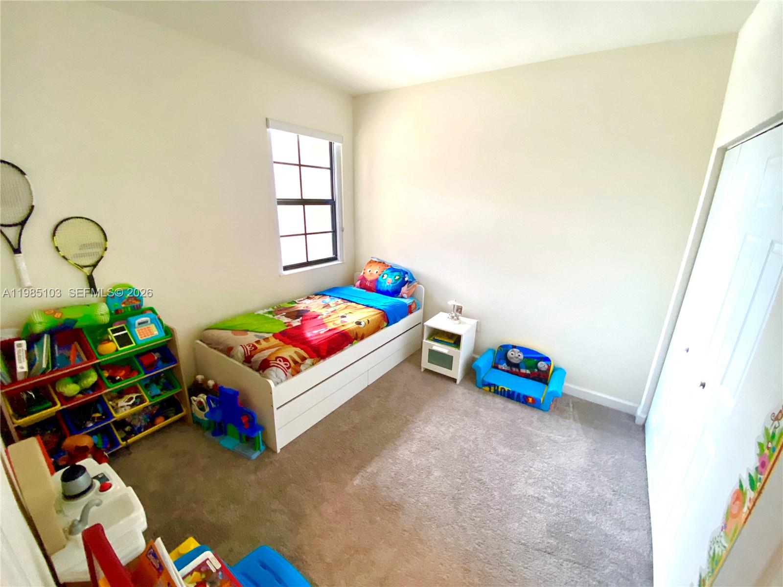 11489 Southwest 250th Street, Unit 11489 Homestead, FL 33032 - Photo 17 of 24 a bedroom with toys and a wooden floor