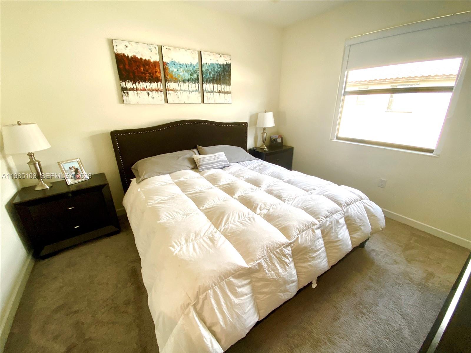 11489 Southwest 250th Street, Unit 11489 Homestead, FL 33032 - Photo 19 of 24 a bedroom with a bed and a window