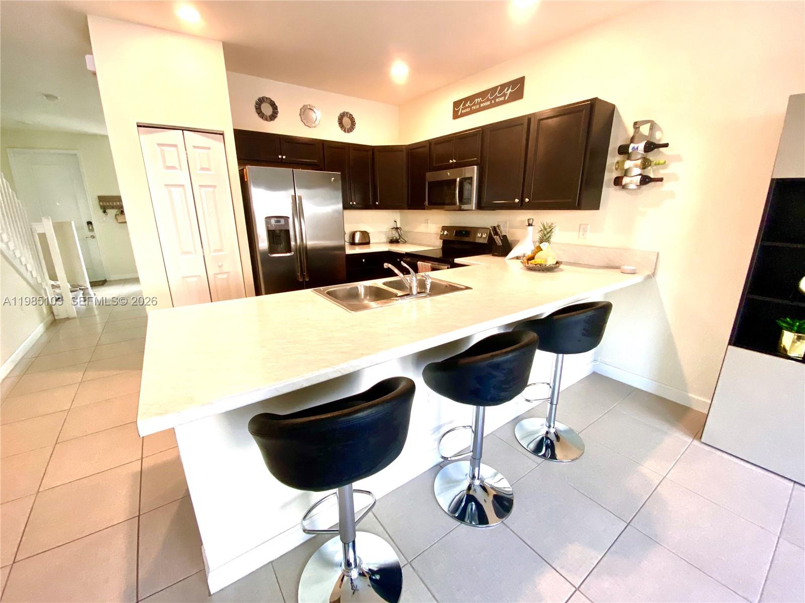11489 Southwest 250th Street, Unit 11489 Homestead, FL 33032 - Photo 2 of 24 a kitchen with a table chairs and a kitchen view