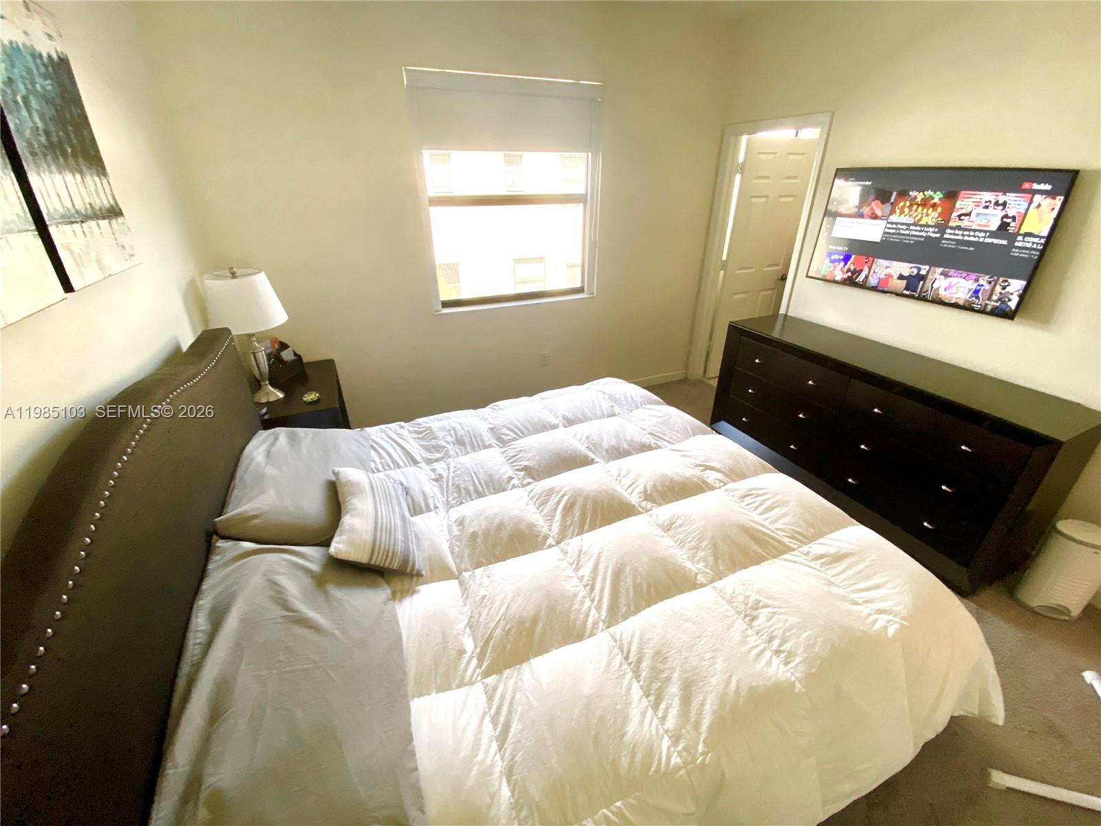 11489 Southwest 250th Street, Unit 11489 Homestead, FL 33032 - Photo 21 of 24 a bedroom with a bed and a painting on the wall