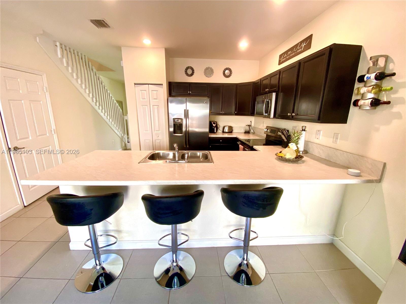 11489 Southwest 250th Street, Unit 11489 Homestead, FL 33032 - Photo 3 of 24 a kitchen with a dining table and chairs