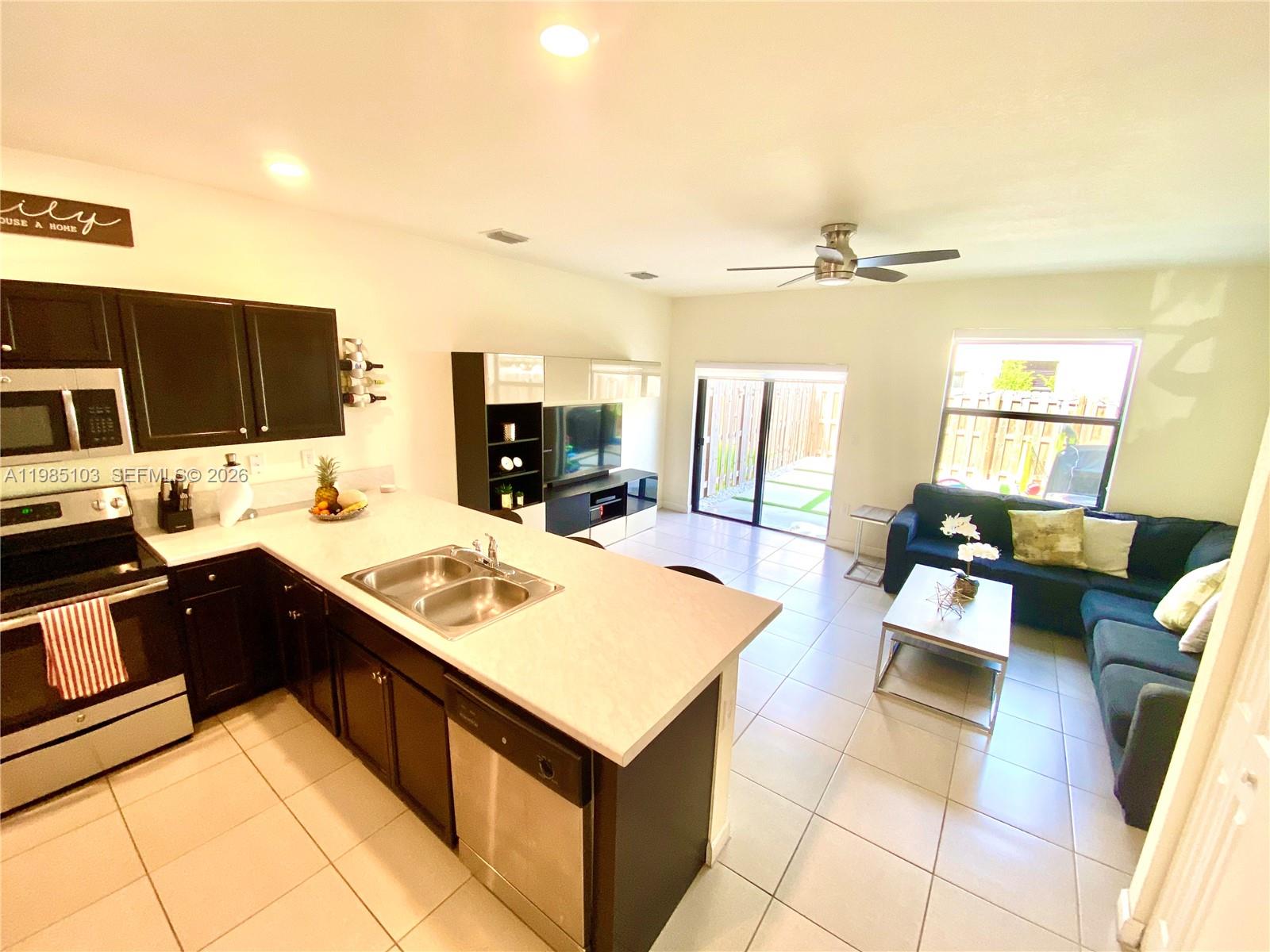 11489 Southwest 250th Street, Unit 11489 Homestead, FL 33032 - Photo 5 of 24 a kitchen with a sink appliances and cabinets