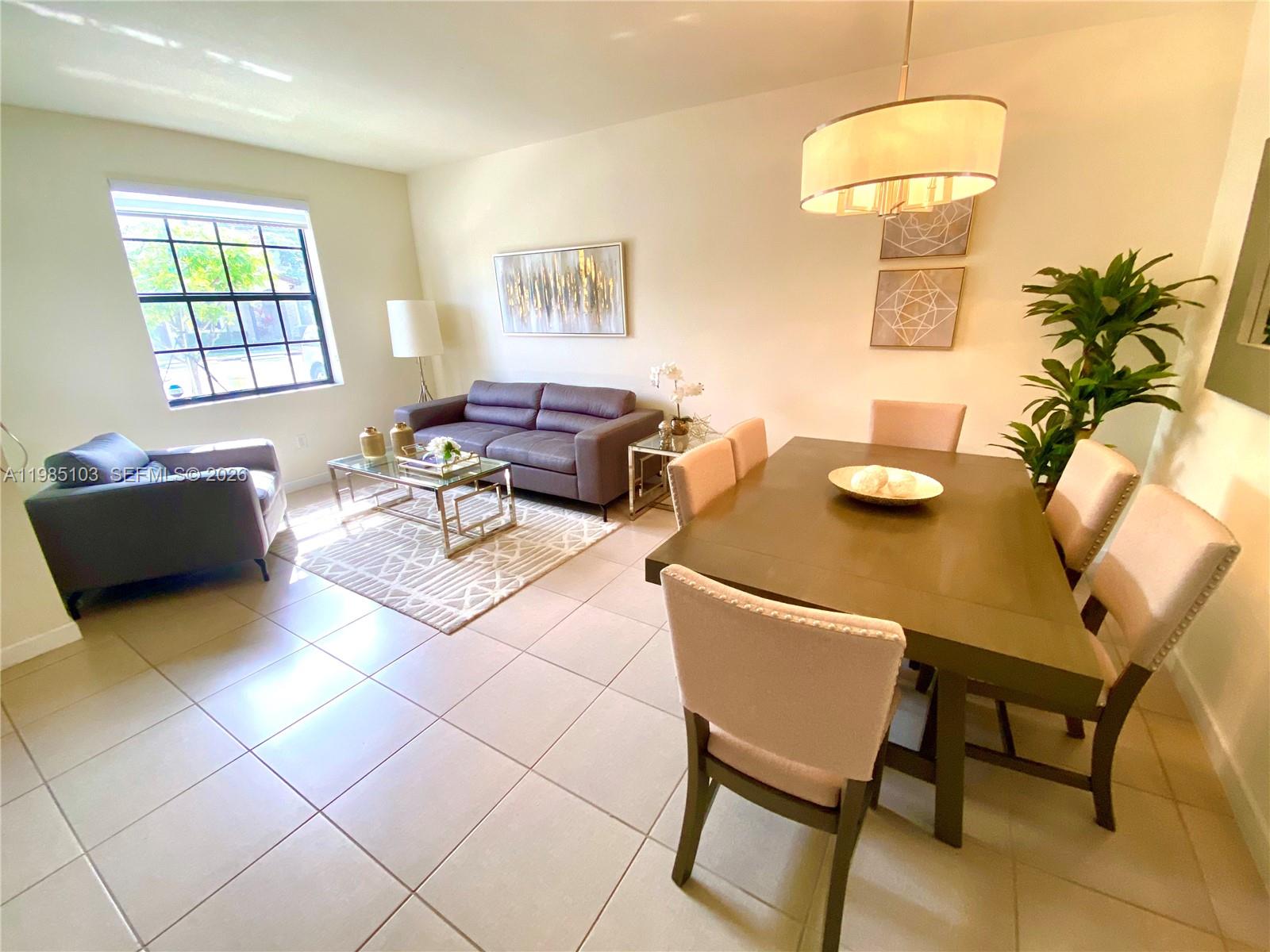 11489 Southwest 250th Street, Unit 11489 Homestead, FL 33032 - Photo 9 of 24 a living room with furniture and a window