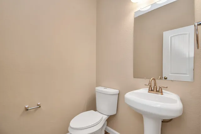 a bathroom with a sink a toilet and mirror