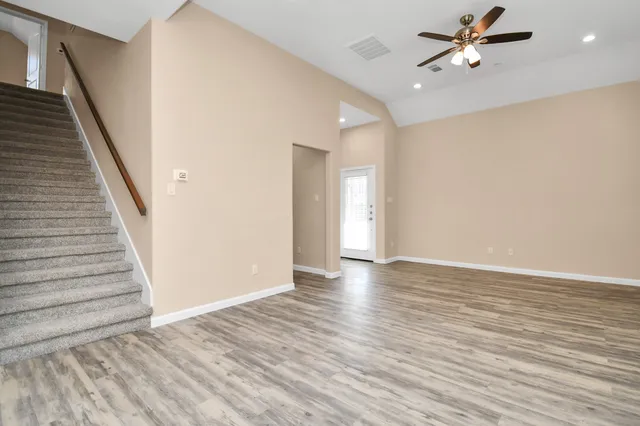 wooden floor in an empty room with a ceiling fan