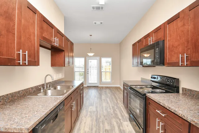a kitchen with granite countertop a sink stove and cabinets