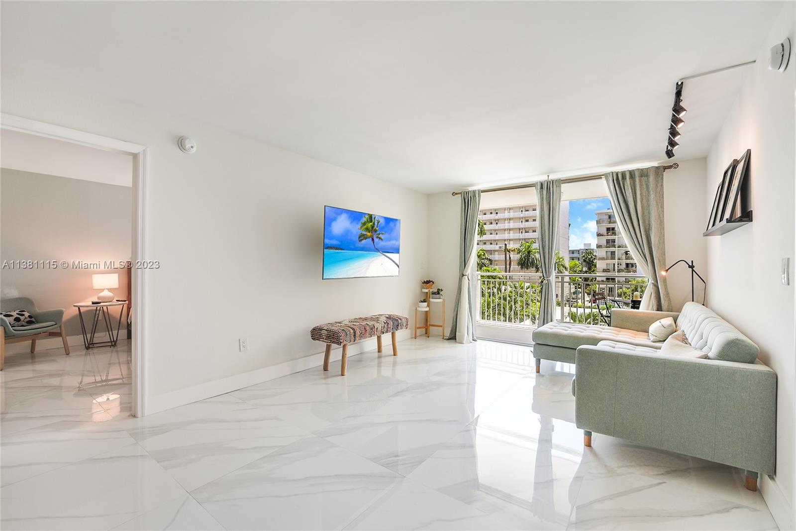 1665 Bay Road, Unit 417 Miami Beach, FL 33139 - Photo 3 of 15 a living room with furniture and a large window