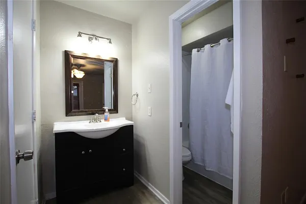a bathroom with a sink a mirror a vanity and a toilet