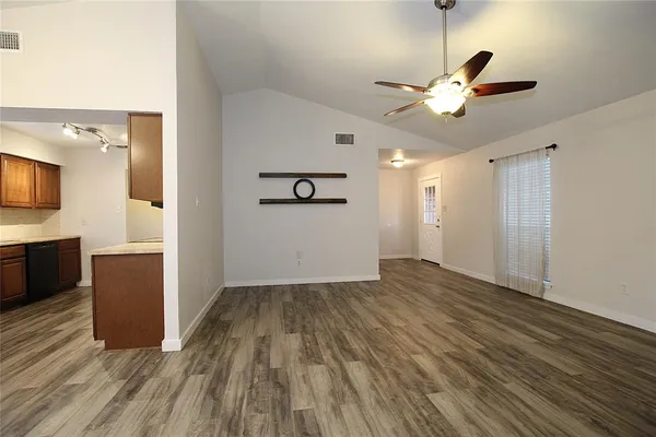a view of empty room with wooden floor