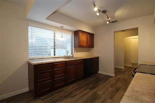 a spacious bathroom with a granite countertop sink a mirror and a bathtub