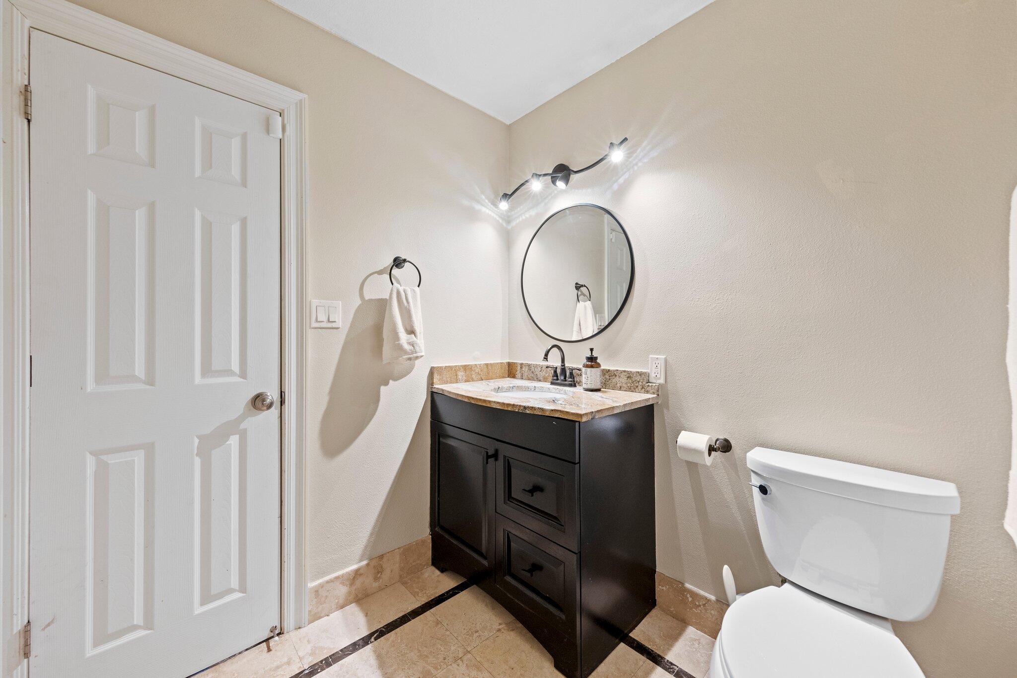 704 Main Street Destin, FL 32541 - Photo 33 of 59 a bathroom with a toilet a sink and a mirror