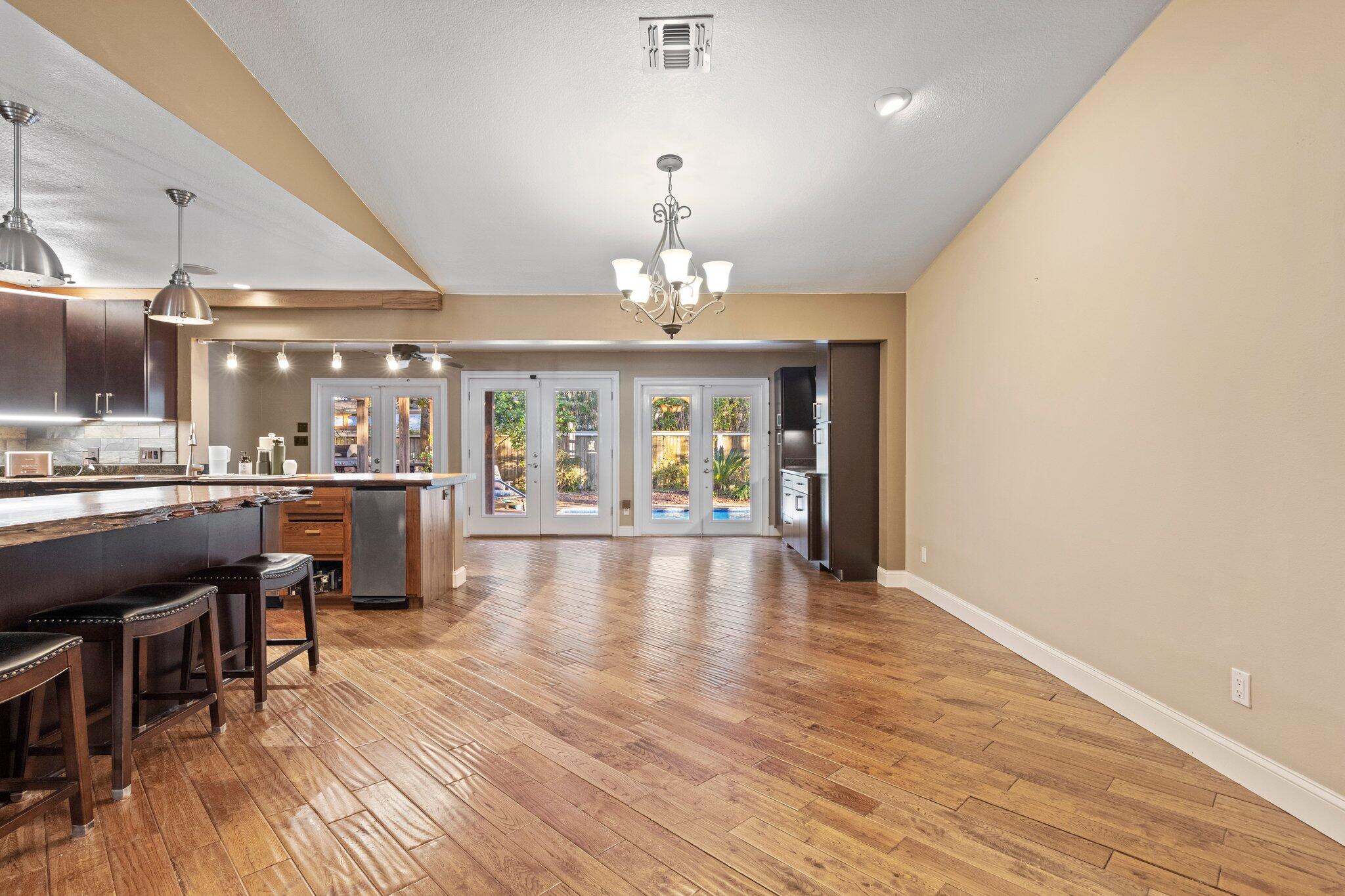 704 Main Street Destin, FL 32541 - Photo 8 of 59 a large room with chandelier fan and wooden floor