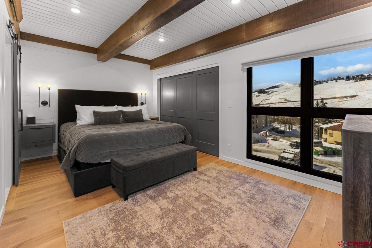 14 Snowmass Road, Unit 308 Crested Butte, CO 81225 - Photo 19 of 40 a bedroom with a large bed and a large window