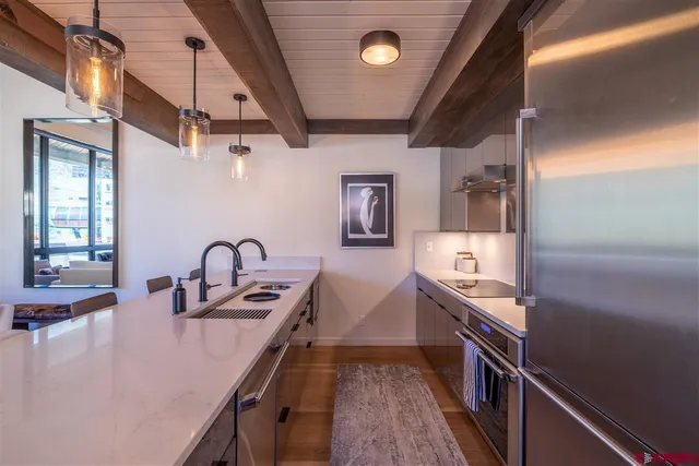 a kitchen with stainless steel appliances a sink stove and refrigerator