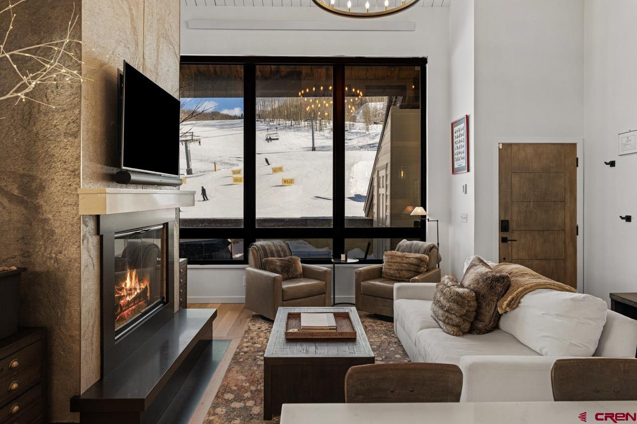 14 Snowmass Road, Unit 308 Crested Butte, CO 81225 - Photo 10 of 40 a living room with furniture a flat screen tv and a fireplace