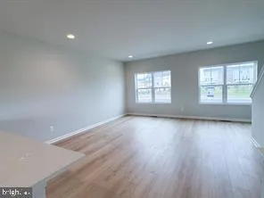 a view of a kitchen with wooden floor and electronic appliances