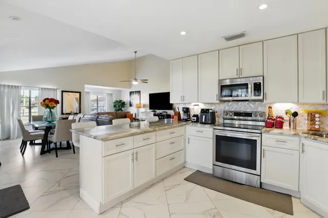 a kitchen with cabinets stainless steel appliances and sink
