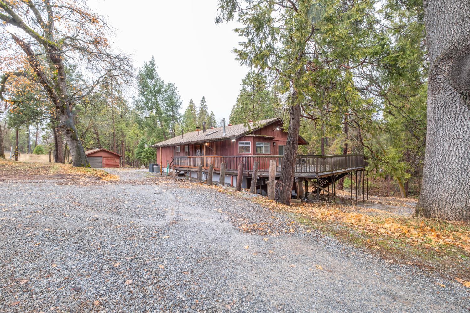 7701 Sly Park Road Placerville, CA 95667 - Photo 1 of 35 a view of a house with large trees and sitting area