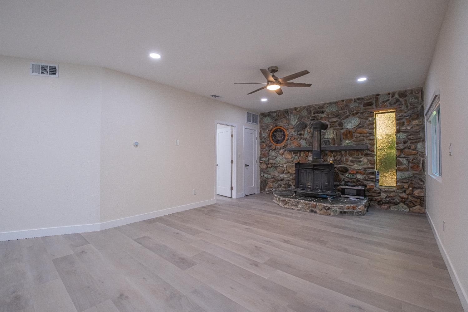 7701 Sly Park Road Placerville, CA 95667 - Photo 15 of 35 an empty room with furniture and a fireplace