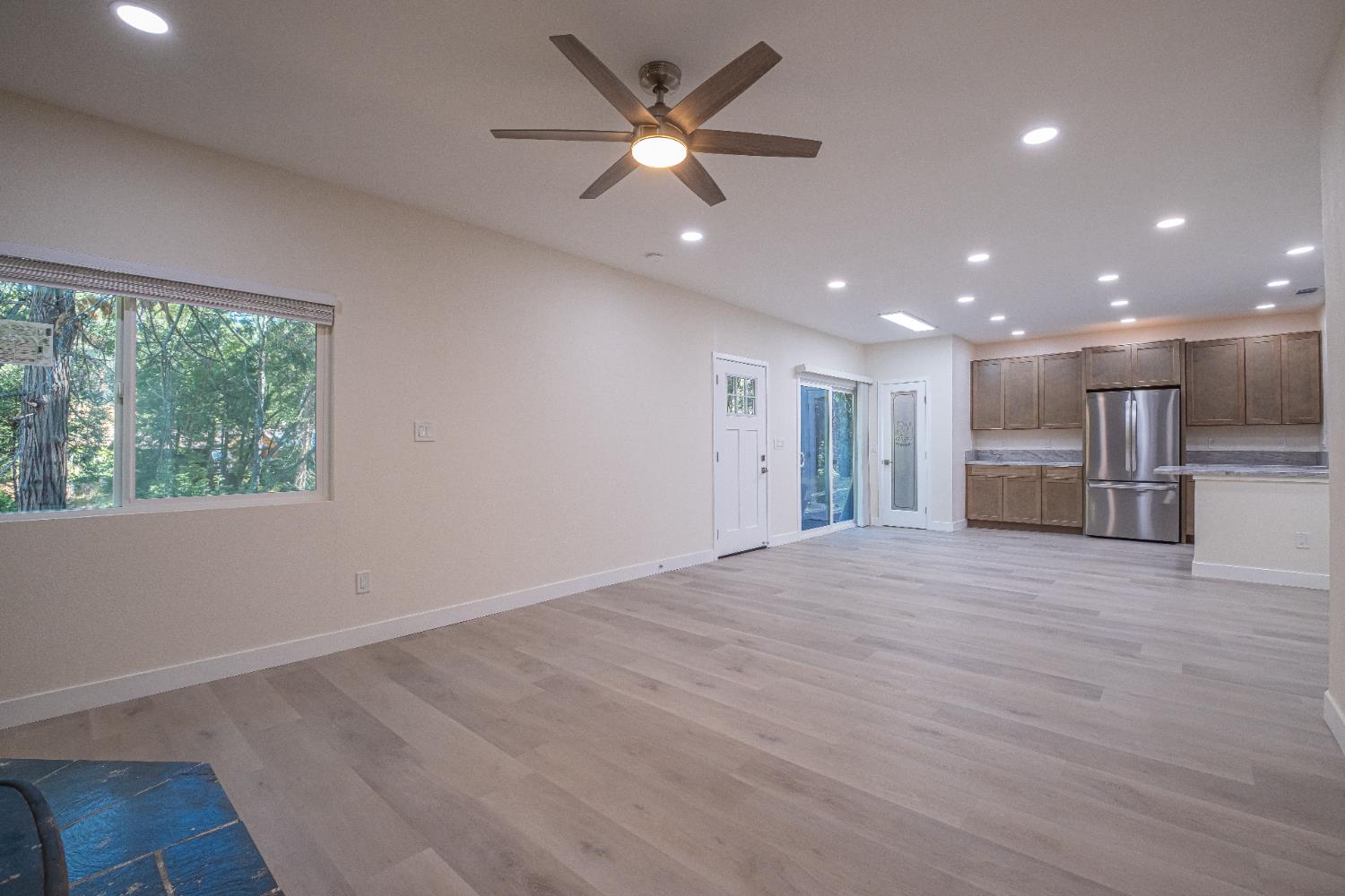 7701 Sly Park Road Placerville, CA 95667 - Photo 17 of 35 an empty room with wooden floor and a kitchen