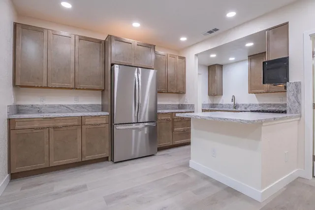 a kitchen with granite countertop a stove and cabinets