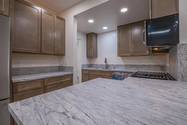 a kitchen with stainless steel appliances granite countertop a stove and a microwave