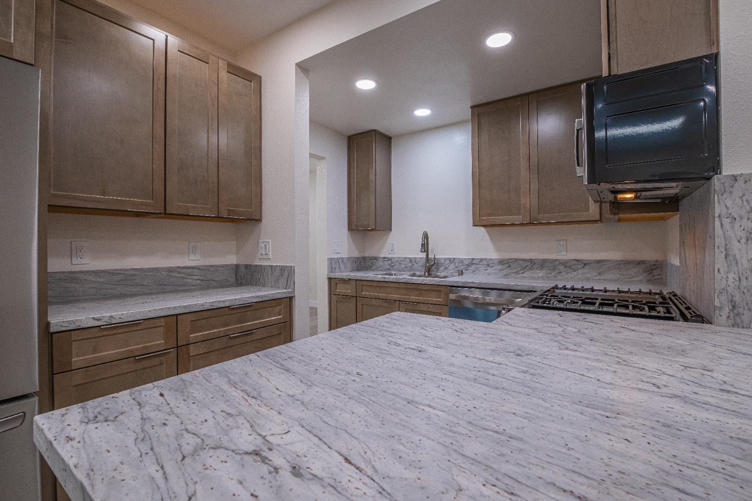 7701 Sly Park Road Placerville, CA 95667 - Photo 9 of 35 a kitchen with granite countertop a stove and cabinets