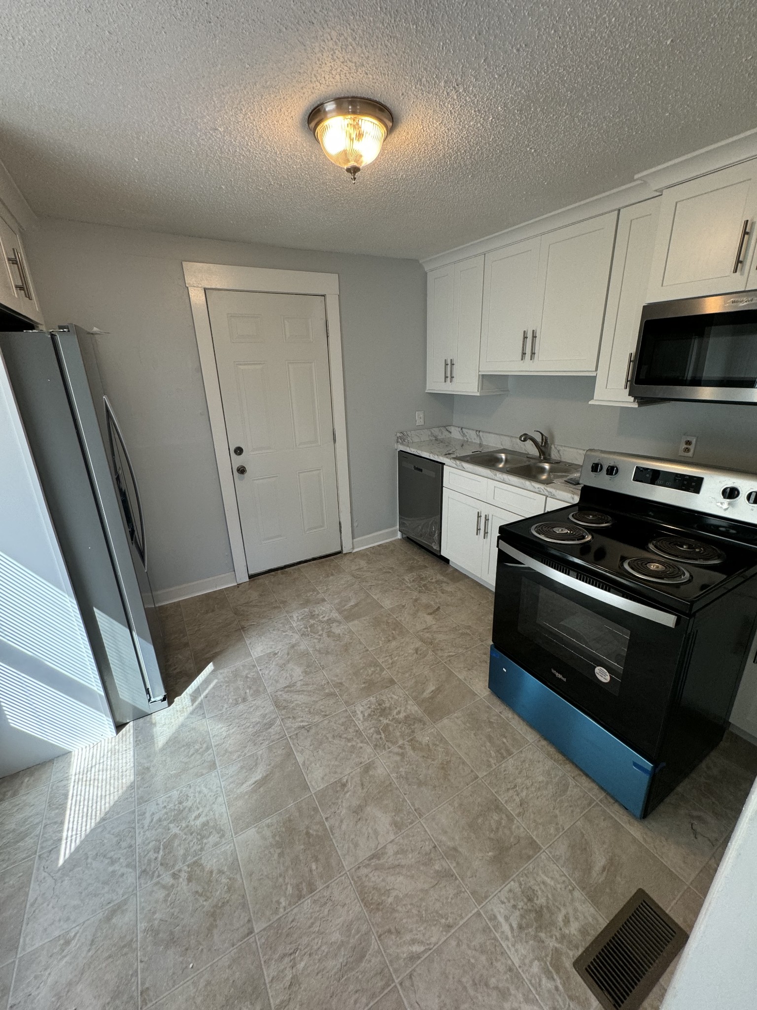 1104 Riverside Drive Murfreesboro, TN 37129 - Photo 3 of 8 a kitchen with stainless steel appliances a stove a sink and a refrigerator
