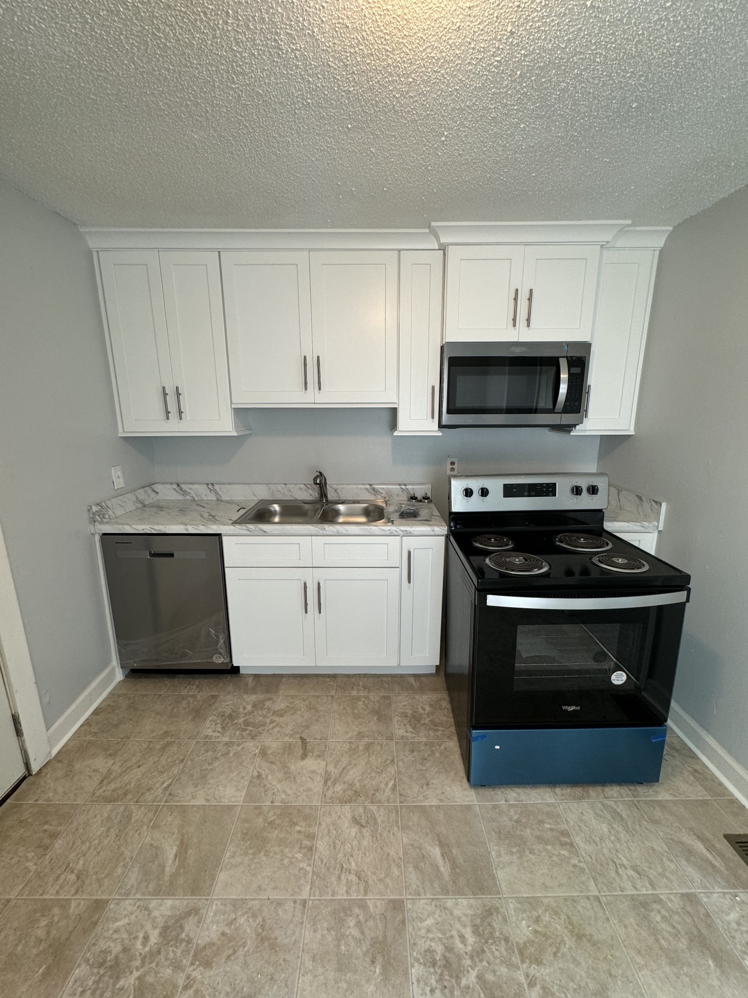 1104 Riverside Drive Murfreesboro, TN 37129 - Photo 5 of 8 a kitchen with stainless steel appliances a stove a microwave sink and cabinets