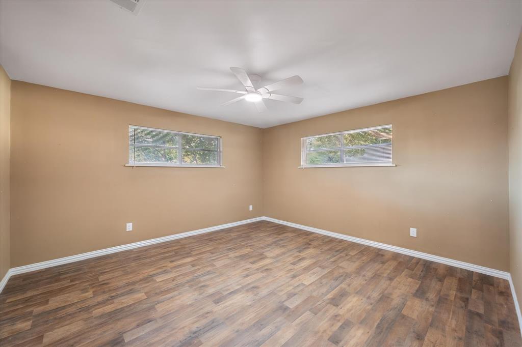 3400 Emhouse Road Corsicana, TX 75110 - Photo 31 of 34 Wood-finish flooring, two windows, and a ceiling fan with integrated lighting