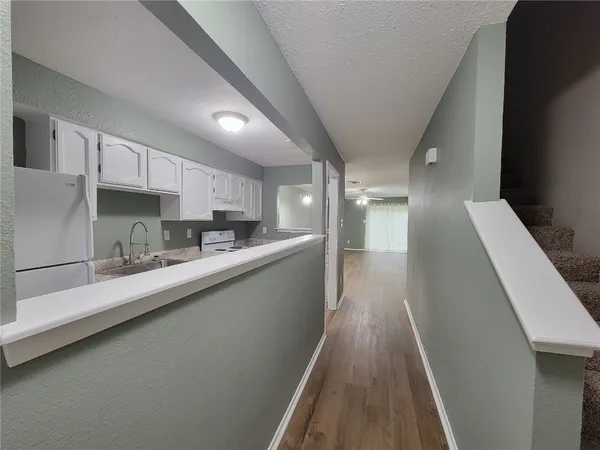 a view of a kitchen with kitchen island wooden floor center island and stainless steel appliances