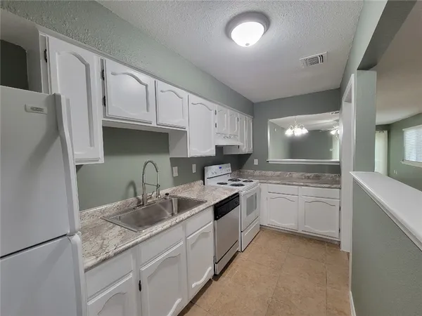 a kitchen with a sink stove and cabinets