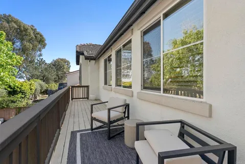 a view of a patio with table and chairs with wooden floor and fence