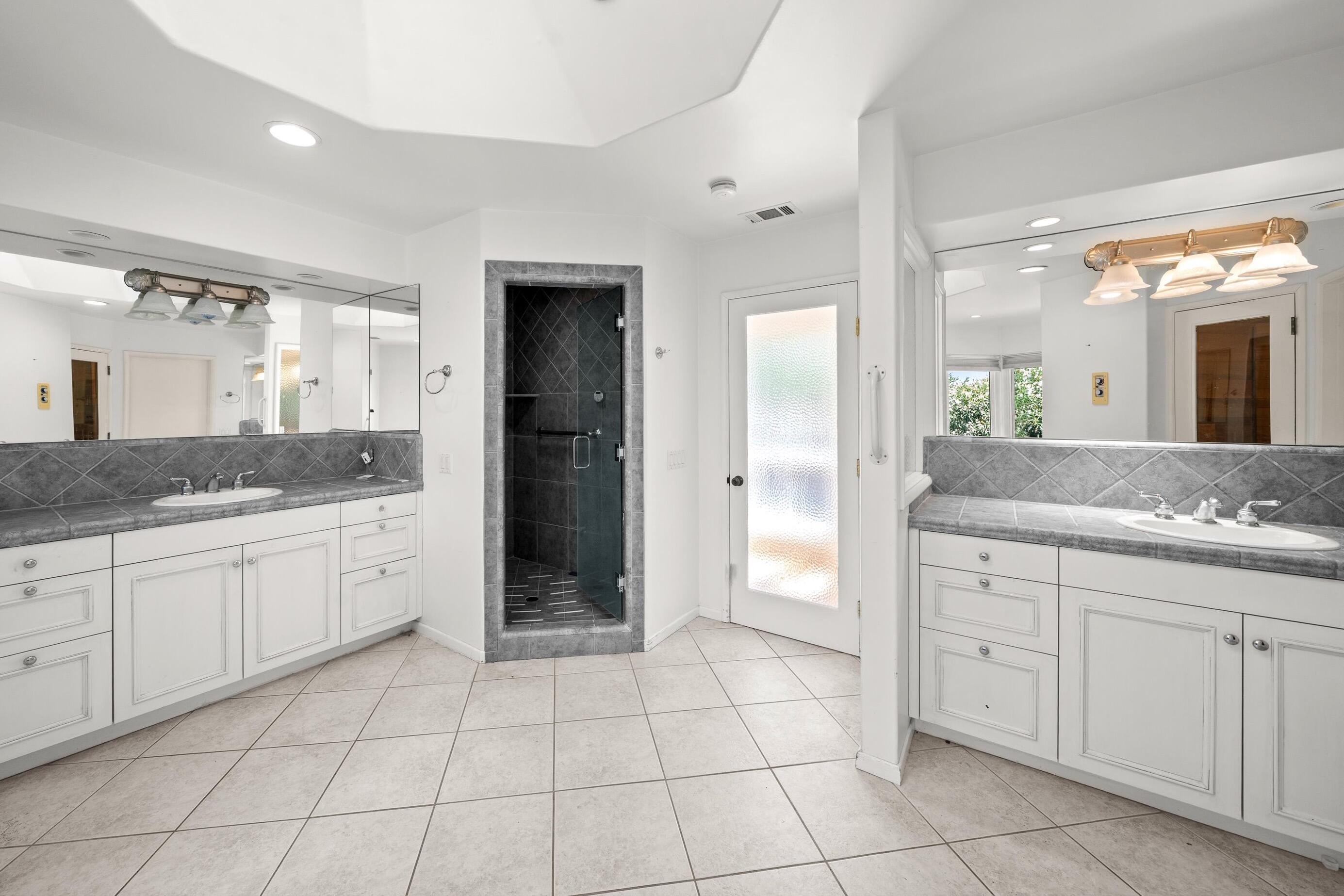 166 Rancho Alisal Drive Solvang, CA 93463 - Photo 13 of 24 a spacious bathroom with a granite countertop sink and a mirror