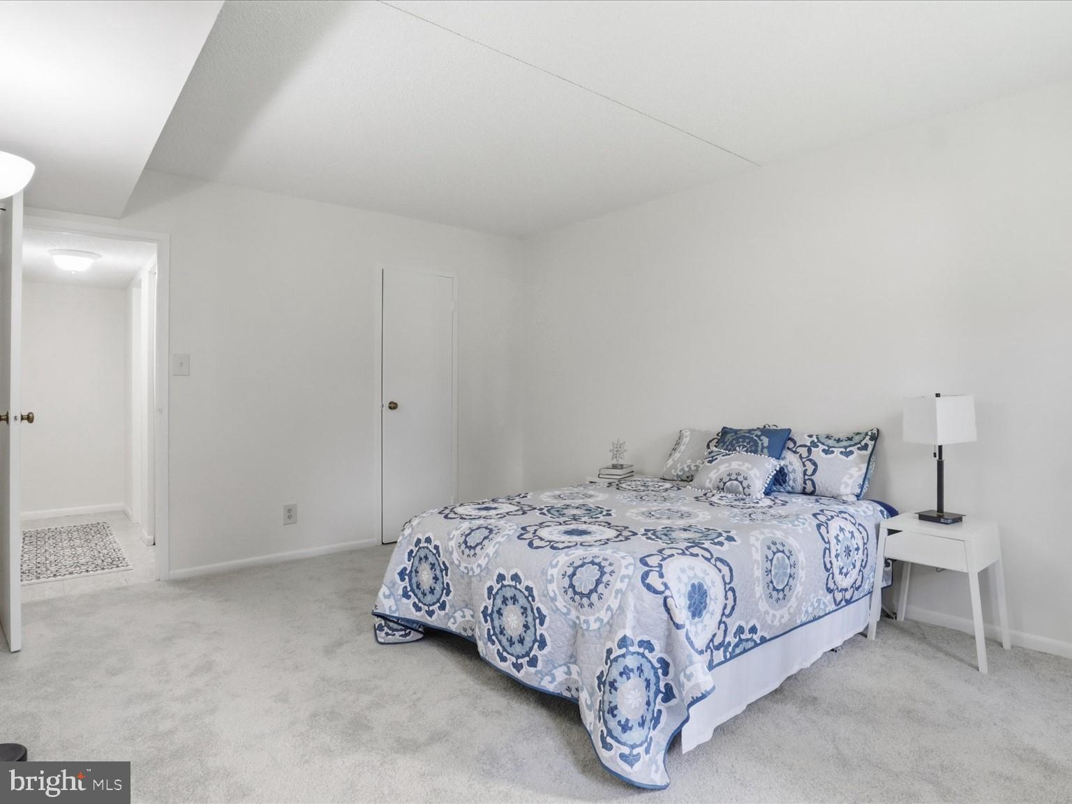 11809 Breton Court, Unit 2B Reston, VA 20191 - Photo 18 of 29 a bedroom with a bed and a night stand