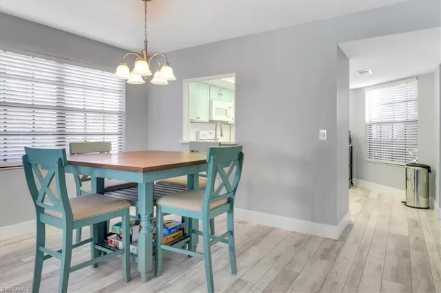 a dining room with furniture a chandelier and wooden floor