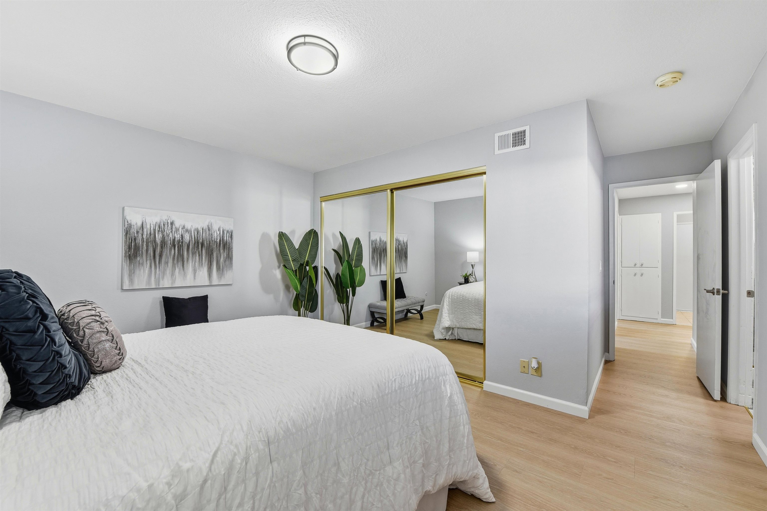 37768 Rockspray Street Newark, CA 94560 - Photo 21 of 34 a bedroom with a large bed and a potted plant