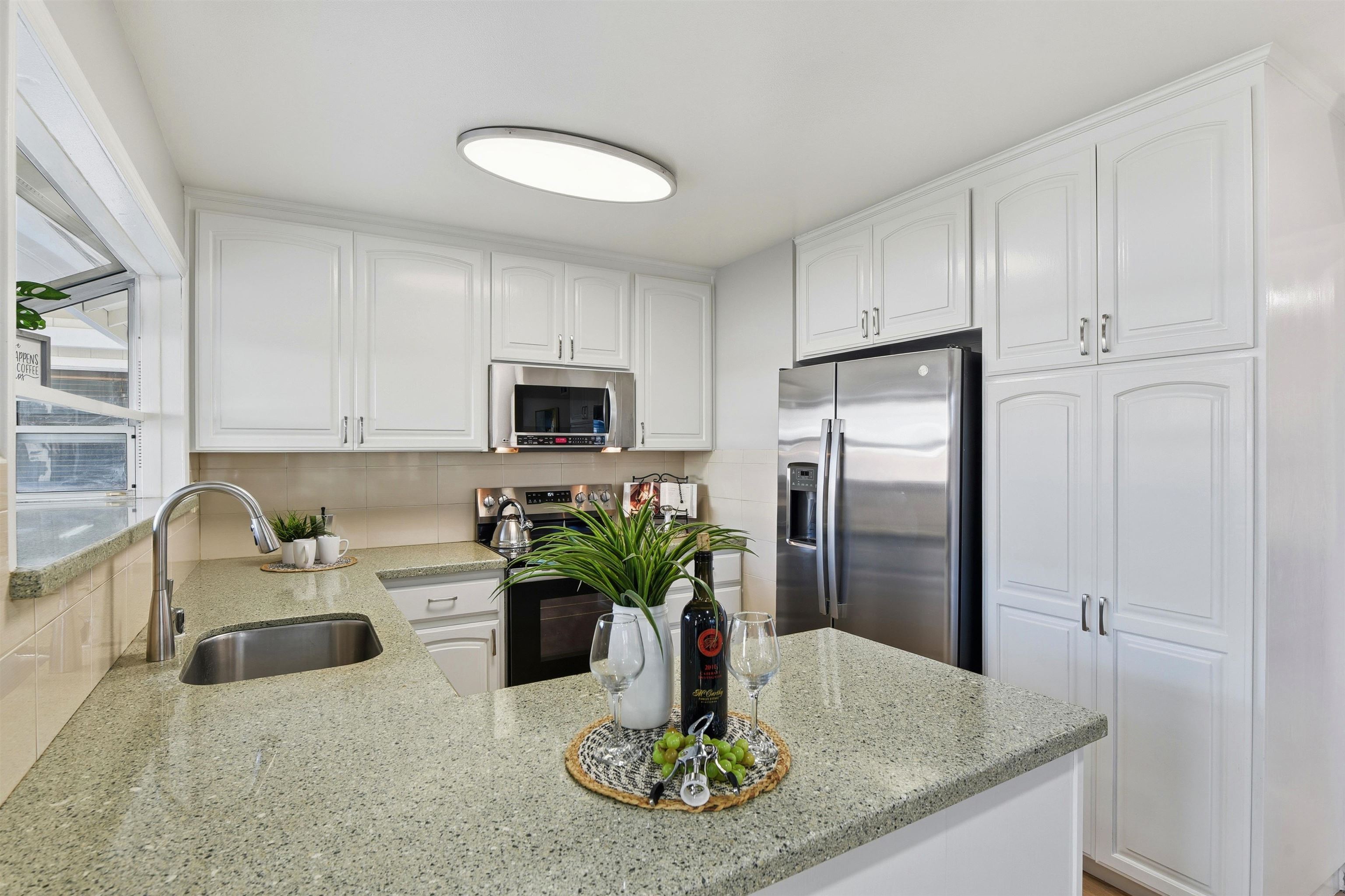37768 Rockspray Street Newark, CA 94560 - Photo 10 of 34 a kitchen with stainless steel appliances granite countertop a refrigerator a stove a sink a dining table and chairs with wooden floor