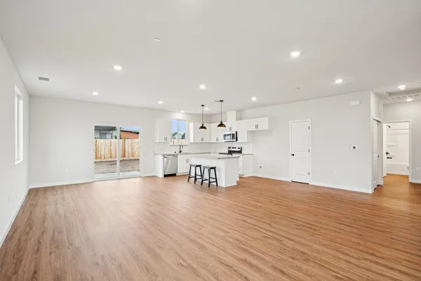 a view of an empty room with wooden floor