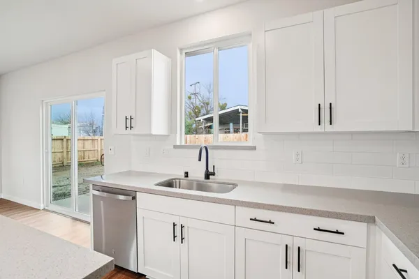 a kitchen with appliances a sink and cabinets