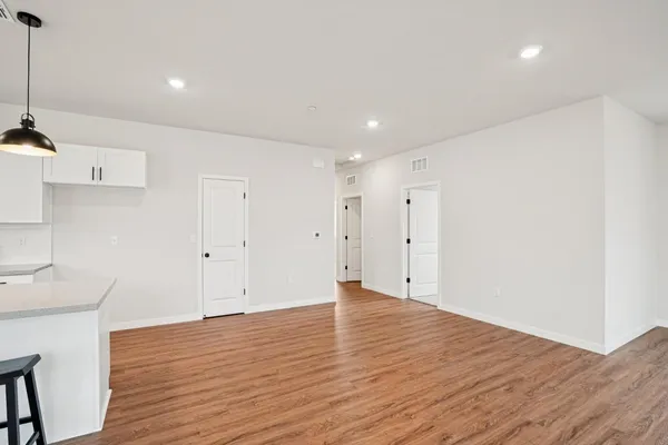 a view of an empty room with wooden floor