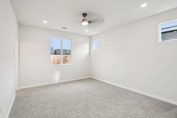an empty room with a bathroom and mirror