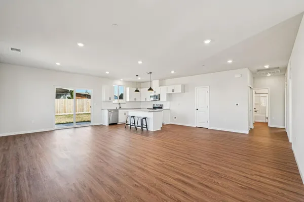 a view of kitchen with a sink wooden cabinets and glass door