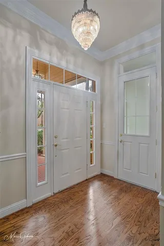 a view of a livingroom with a fireplace wooden floor and windows