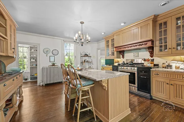 a kitchen with stainless steel appliances granite countertop a stove top oven a refrigerator a sink and dining table with wooden floor