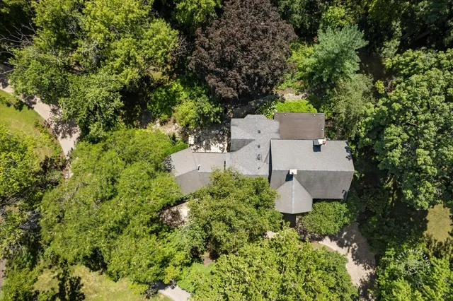 an aerial view of a house with a yard and trees